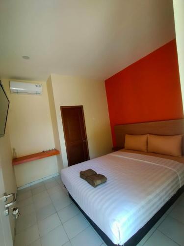 卡里蒙贾瓦Spazio Hotel的一间卧室设有一张红色墙壁的大床