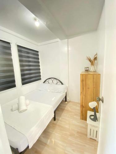 NaicCabuhat-Duco Lodge 3的白色的客房设有两张床和窗户。