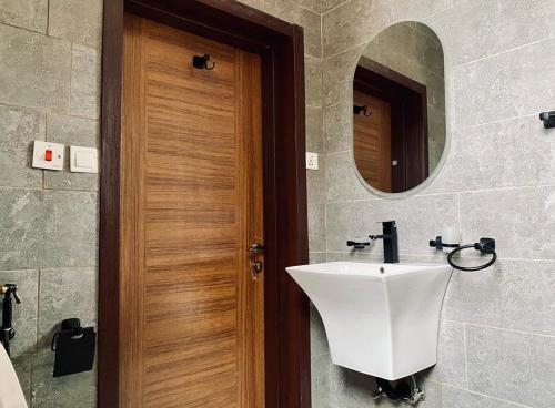 基加利LUXURYSTAY-CATION的一间带水槽和木门的浴室