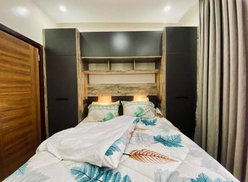 基加利LUXURYSTAY-CATION的一间卧室配有一张带木制床头板的床