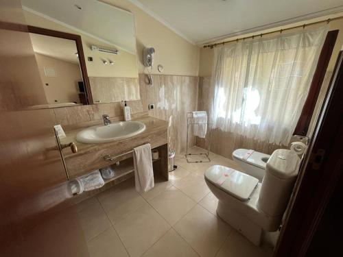 翁蒂年特卡萨尔酒店的一间带水槽、卫生间和镜子的浴室