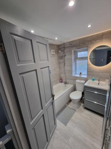诺丁汉Dulverton house - 3 bed house /sleeps 6+ driveway+close to M1的浴室设有门、浴缸和卫生间。