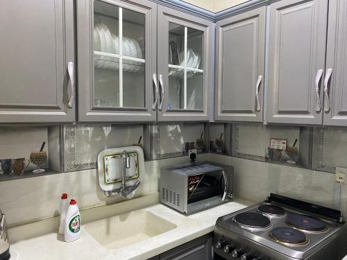 欧普尔شالية 3 غرف على شرم ابحر - جدة - السعودية的厨房配有白色橱柜和微波炉