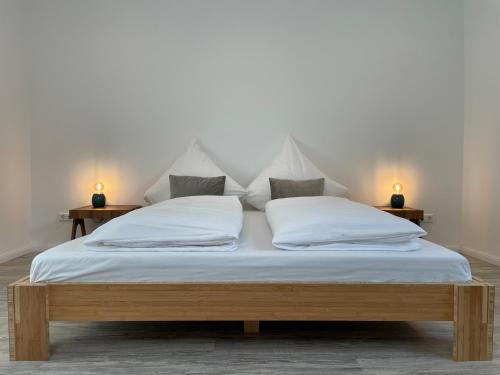 汉诺威SPLENDID I Unique Spacious Apartment的一张带白色床单和枕头的床以及两盏灯