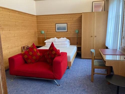 斯派克FriendsHouse Appenzellerhof的一间卧室配有红色的沙发和一张床