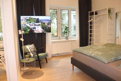 格拉茨City Apartment Rudolf 26m2的一间卧室配有一张床,并在一间客房内配有电视。