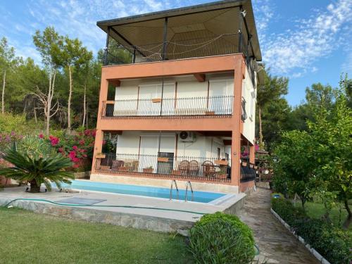 马纳夫加特ormanın içinde geniş havuzlu triplex villa的一座房子前面设有游泳池