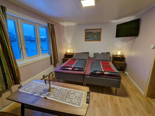 ValsøybotnOvernatting Rodal的客厅配有两张床和一张桌子