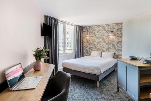 圣艾蒂安Le Parc 42 Saint-Etienne的酒店客房配有一张床、一张书桌和一台笔记本电脑