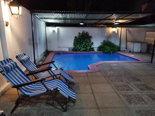 圣地亚哥Costanera Bed & Breakfast的游泳池旁设有2把躺椅