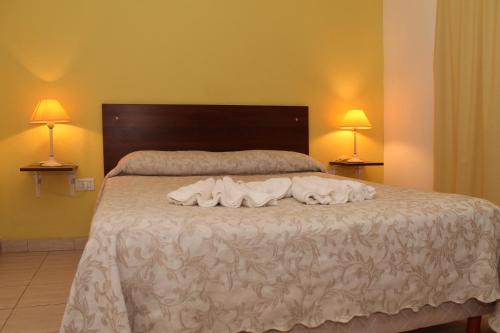 科隆布里萨斯拉戈公寓酒店的一间卧室配有一张床,上面有两条毛巾