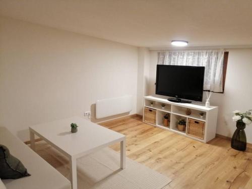 维也纳Gesamtes Haus mit Garten - 100% Privatsphäre的客厅配有电视和白色桌子
