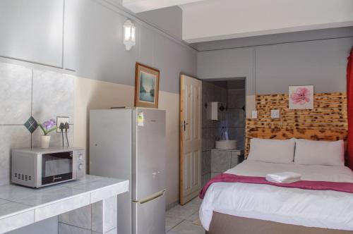 吕德里茨OceanLife Accommodation Luderitz的一间小卧室,配有一张床和一台微波炉