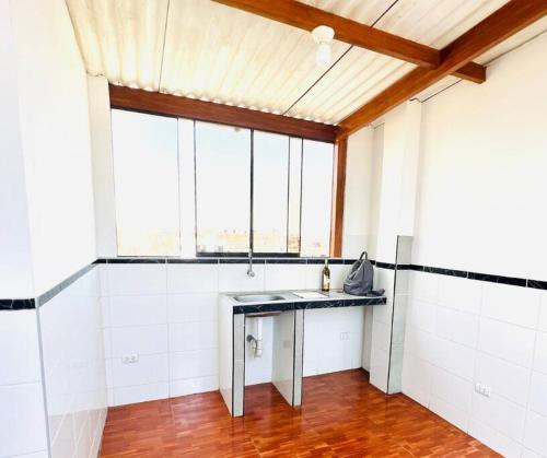 卢林Minidepartamento en Lurín的带窗户的客房内设有带桌子的厨房