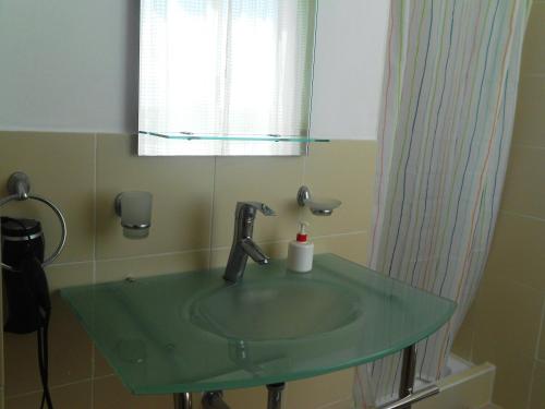 拉罗马纳玛吉之家公寓的一间带绿色水槽和镜子的浴室