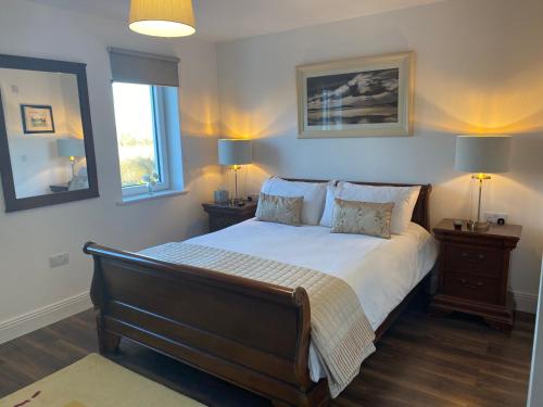 ShanagarryAshlee Lodge P25 K6R6的一间卧室配有一张带2个床头柜和2盏灯的床。