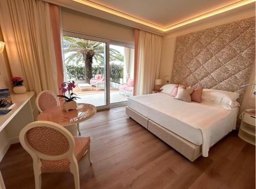 利尼亚诺萨比亚多罗Riviera Resort Hotel的卧室配有一张床和一张桌子及椅子
