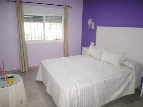 埃尔帕尔马Hostal Restaurante La Ilusion的卧室配有白色的床和紫色的墙壁
