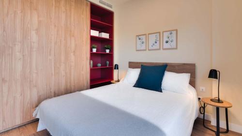 阿尔考本达斯Livensa Living Studios Madrid Alcobendas的一间卧室设有一张床和一个红色书架