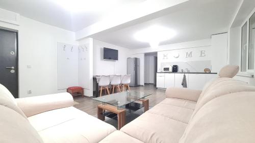 瓦特拉多尔内Apartament In Inima Dornei的白色的客厅配有白色的沙发和桌子