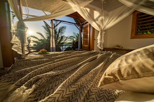 Nosy KombaKomba Cabana的一间卧室设有一张大床,享有棕榈树的景色