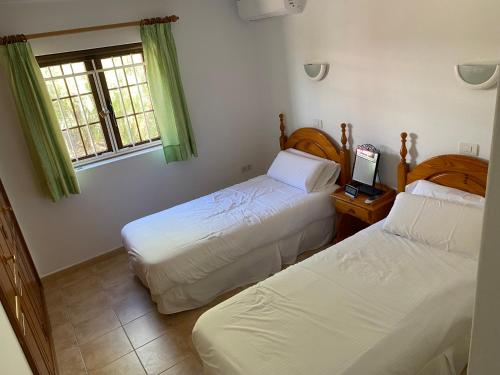 普拉亚布兰卡Las Brisas, Villa 98的一间卧室配有两张床和一张桌子上的笔记本电脑