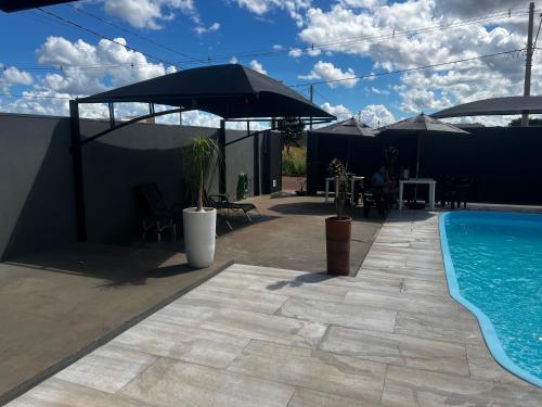 多拉杜斯JOTA Área de Lazer的一个带遮阳伞的游泳池和庭院
