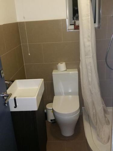 MordenLOVELY 1 BED FLAT WITH GOOD TRANSPORT LINKS.的浴室配有白色卫生间和盥洗盆。