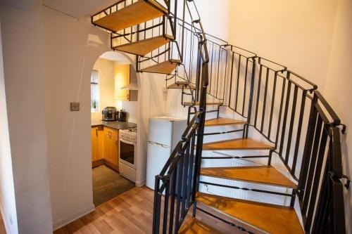 曼彻斯特Entire 1 Bedroom House in Manchester的房屋内螺旋楼梯,带厨房