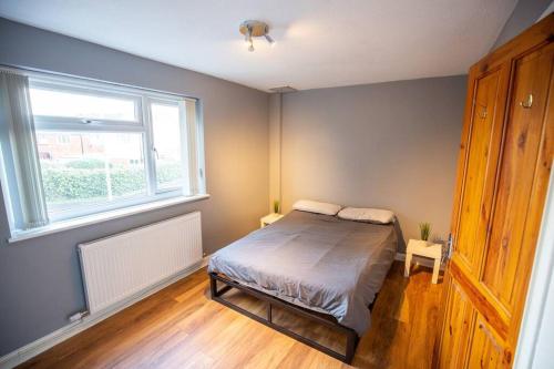 曼彻斯特Entire 1 Bedroom House in Manchester的一间卧室设有一张床和一个窗口