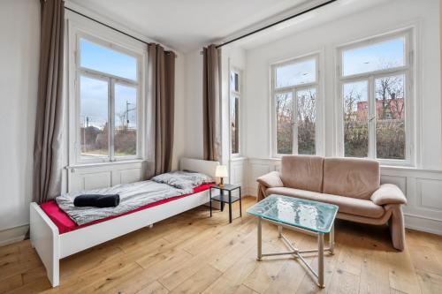 梅青根home2stay worker Apartments Metzingen的一间卧室配有一张床、一张沙发和窗户。
