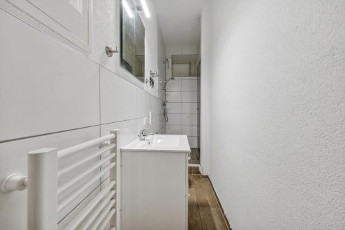梅青根home2stay worker Apartments Metzingen的白色的浴室设有水槽和镜子