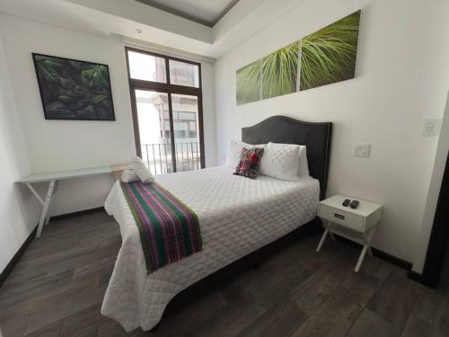 危地马拉L1C 301 - Boutique apartment in Cayala for 4 guests的一间卧室配有一张带书桌的床和窗户。