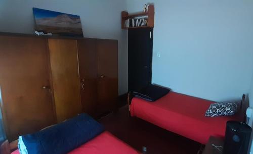 奇莱西托Casa Huésped Shalom的一间卧室配有两张床、一个衣柜和一张红色的床。