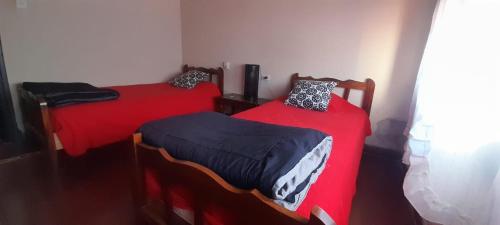 奇莱西托Casa Huésped Shalom的红色床单间内的两张单人床