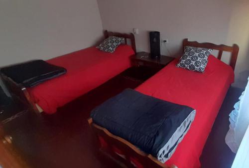 奇莱西托Casa Huésped Shalom的两张床铺,位于带红色床单的房间