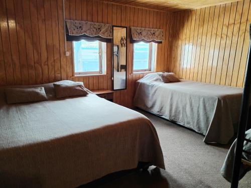 蒙特港Hostal Copiapó Puerto Montt的一间卧室设有两张床和两个窗户。