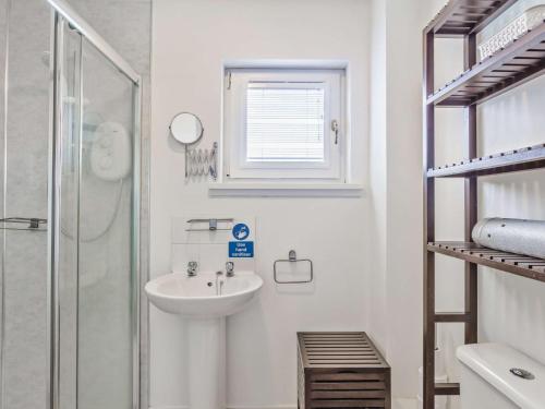 托明陶尔4 Bed in The Cairngorms 46162的白色的浴室设有水槽和淋浴。