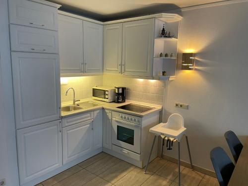 库克斯港Haus Baltic Koje 04的小厨房配有白色橱柜和水槽