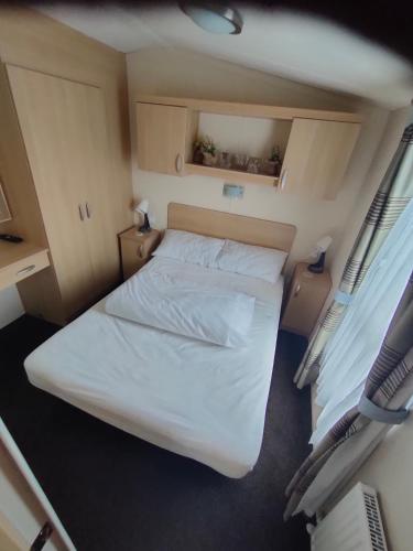 巴茅思M&C Caravan Hire Sunnysands的一间小卧室,配有床和2个窗户