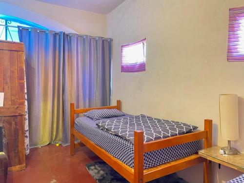 拉巴斯Sunset Hostel的一间卧室配有床和带窗帘的窗户