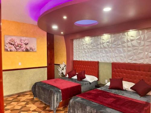 卡西塔斯Hotel La Cueva del Pirata的一间卧室设有两张床和一个紫色的天花板