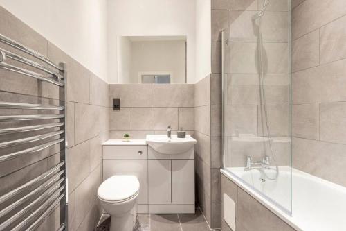 格拉斯哥Stunning Ground Floor flat in Southside.的浴室配有卫生间、盥洗盆和淋浴。