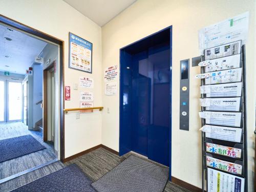 大垣Okasan Hotel - Vacation STAY 45146v的走廊上设有蓝色的门,墙上设有标志