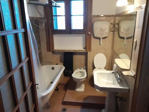 蒙得维的亚Apartamento de estilo en edificio patrimonial的浴室配有卫生间、浴缸和水槽。
