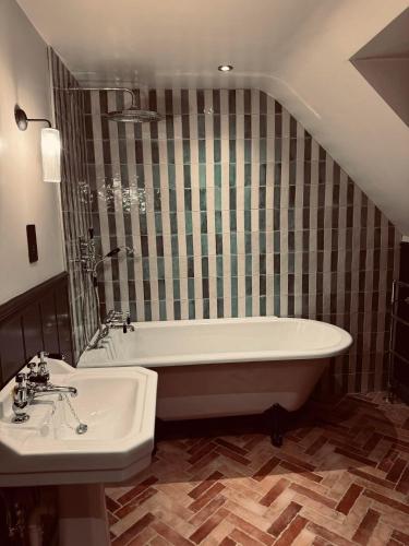 PenshurstThe Leicester Arms Country Inn的带浴缸和盥洗盆的浴室