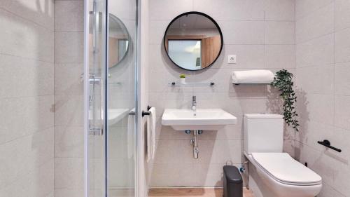 阿尔考本达斯Livensa Living Studios Madrid Alcobendas的一间带卫生间、水槽和镜子的浴室