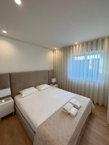 维拉诺瓦-德法马利Brittos Home Lovely Stay - Villa Prime in VN de Famalicão Braga的一间卧室配有一张大床和两条毛巾