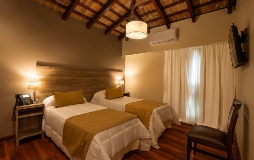 拉库布蕾Hotel Intersur La Cumbre的酒店客房设有两张床和窗户。