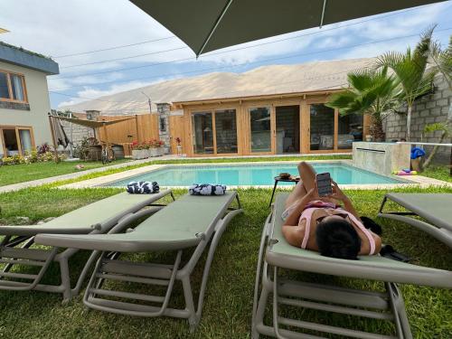 Acari Hotel Resort的躺在游泳池旁草坪椅上的女人